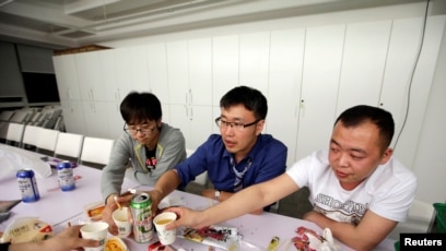 Han Liqun (C), a HR manager of RenRen Credit Management Co., drinks with his colleagues Kou Meng (L) and Ma Zhenguo after finishing work, after midnight, in Beijing, China, April 27, 2016. Office workers sleeping on the job is a common sight in China, ...